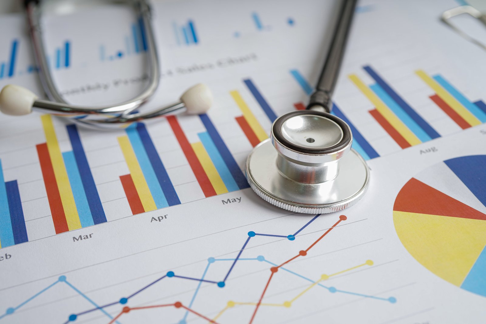 Stethoscope and US dollar banknotes on chart or graph paper, Fin